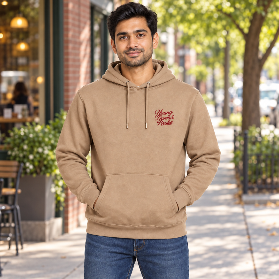 AI-generated lifestyle styling image of Young Dumb & Broke Classic Pullover Hoodie – Light in an everyday neighborhood setting.