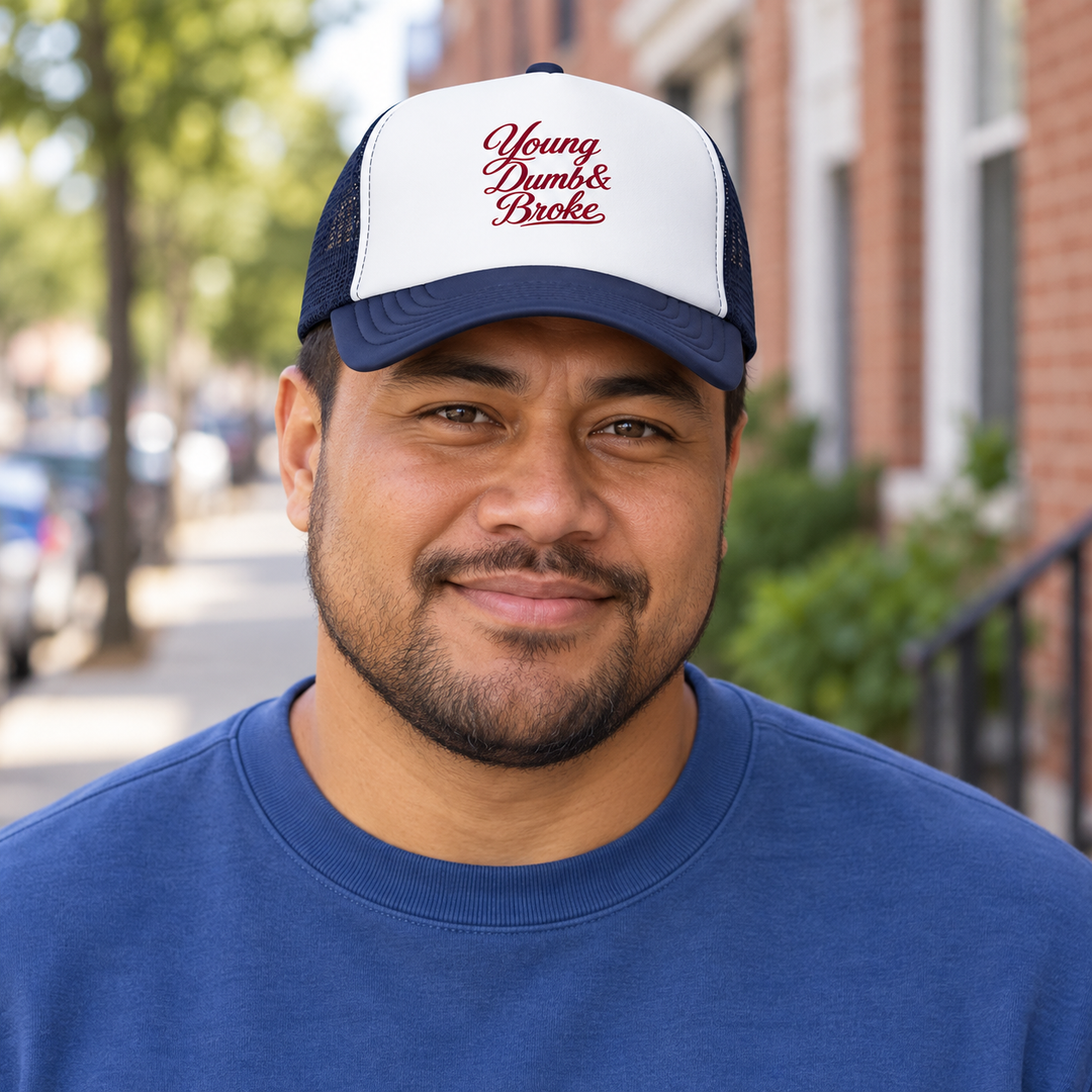 AI-generated lifestyle styling image of Young Dumb & Broke Foam Trucker Hat.