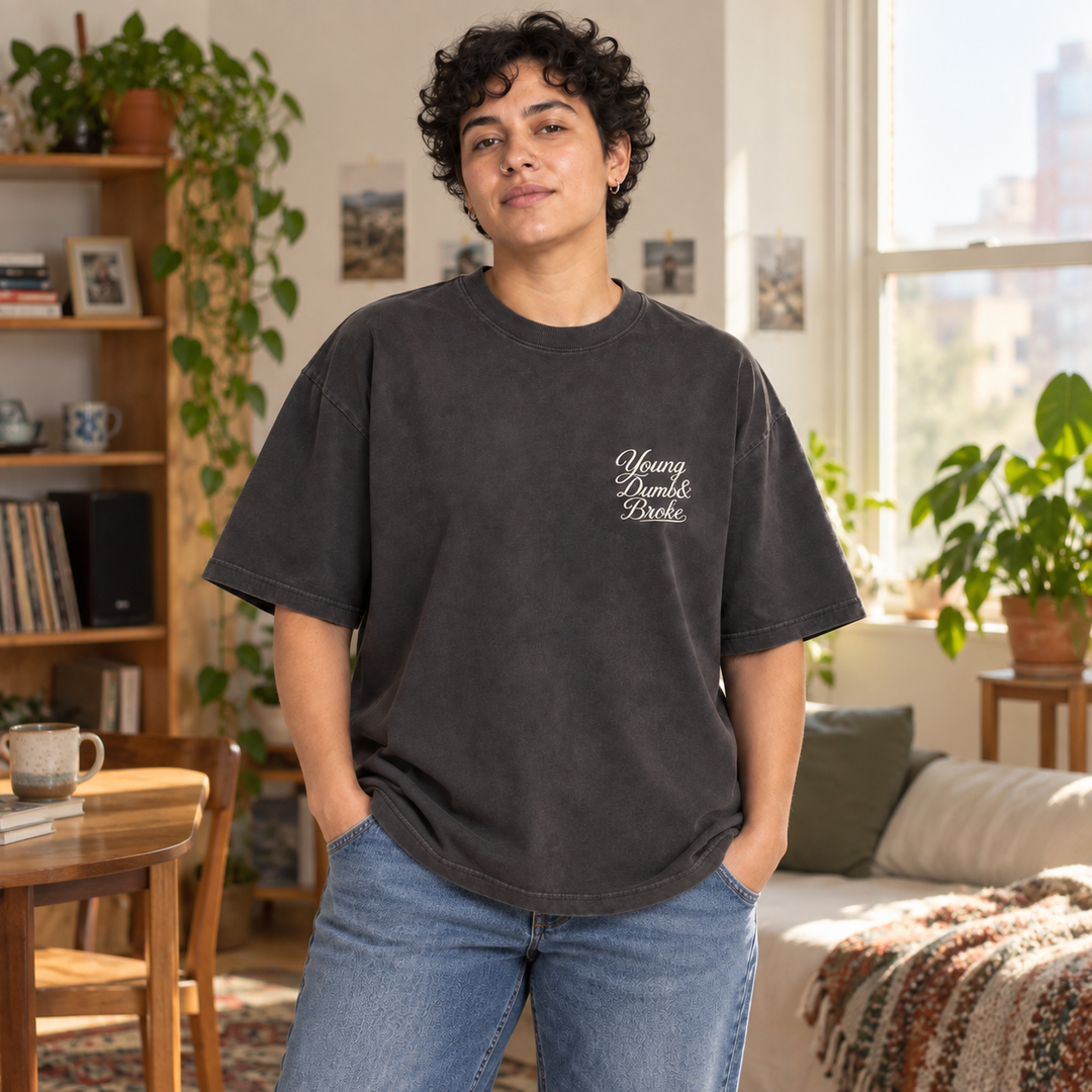AI-generated lifestyle styling image of Young Dumb & Broke Oversized Faded T-Shirt – Dark in an everyday apartment setting.