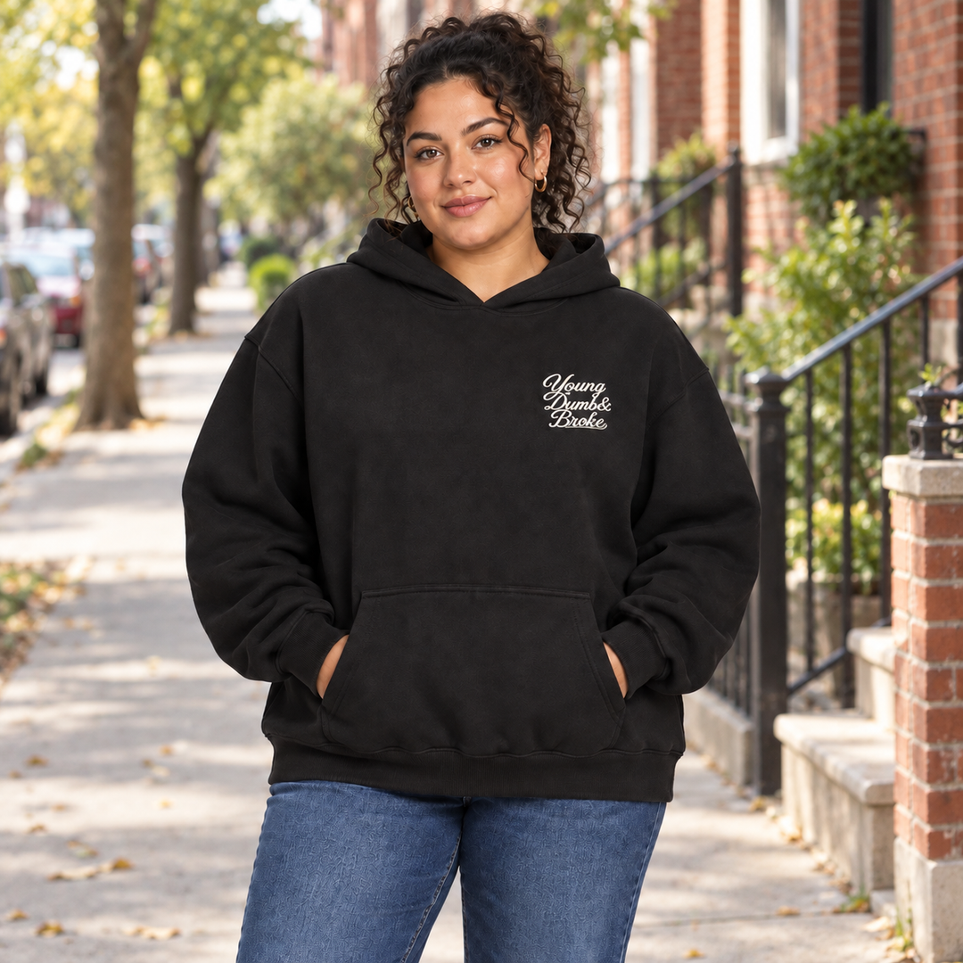 AI-generated lifestyle styling image of Young Dumb & Broke Oversized Hoodie – Dark in an everyday neighborhood setting.