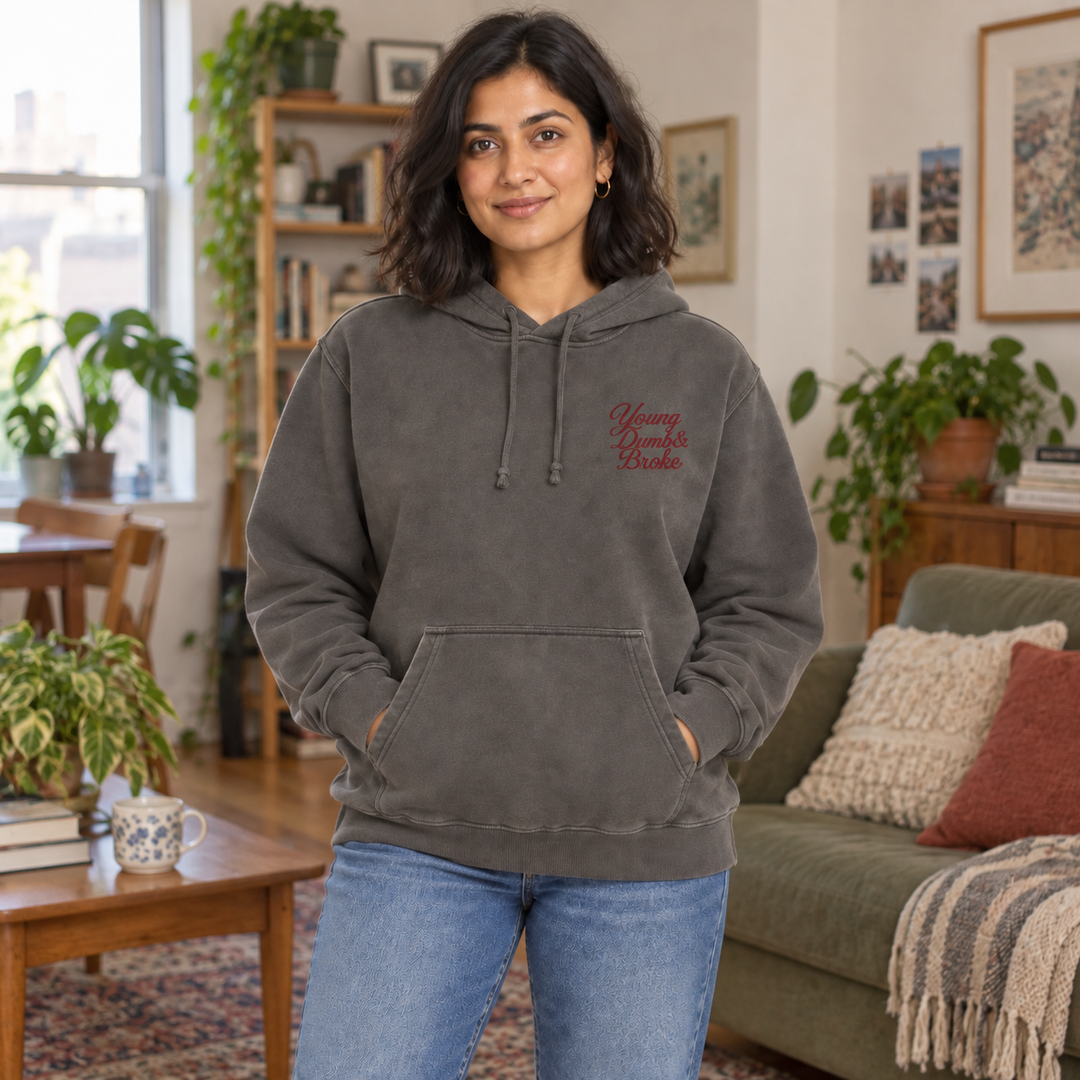 AI-generated lifestyle styling image of Young Dumb & Broke Pigment-Dyed Hoodie in an everyday apartment setting.